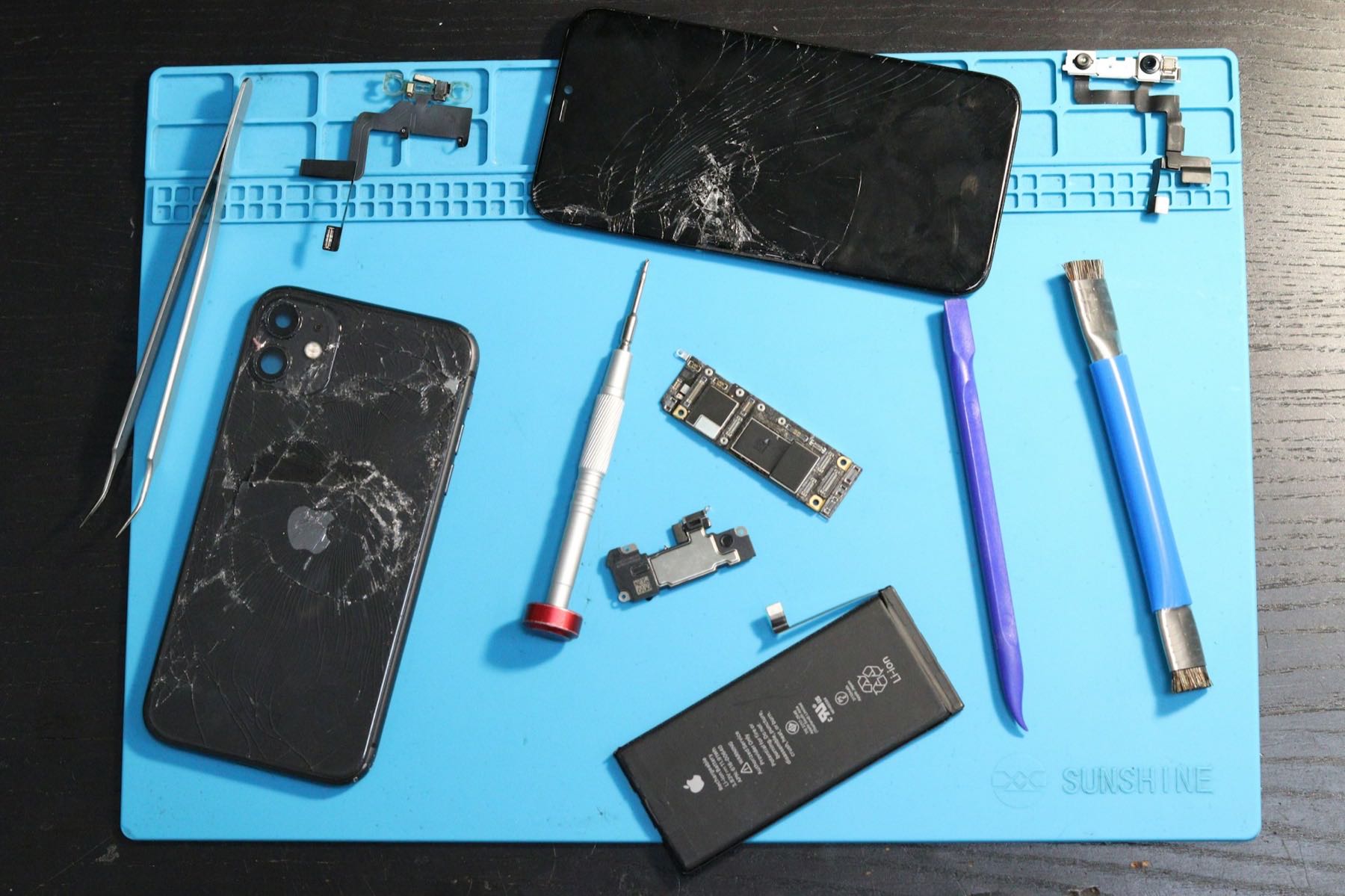 Zerlegte Smartphones auf einer Reparaturmatte